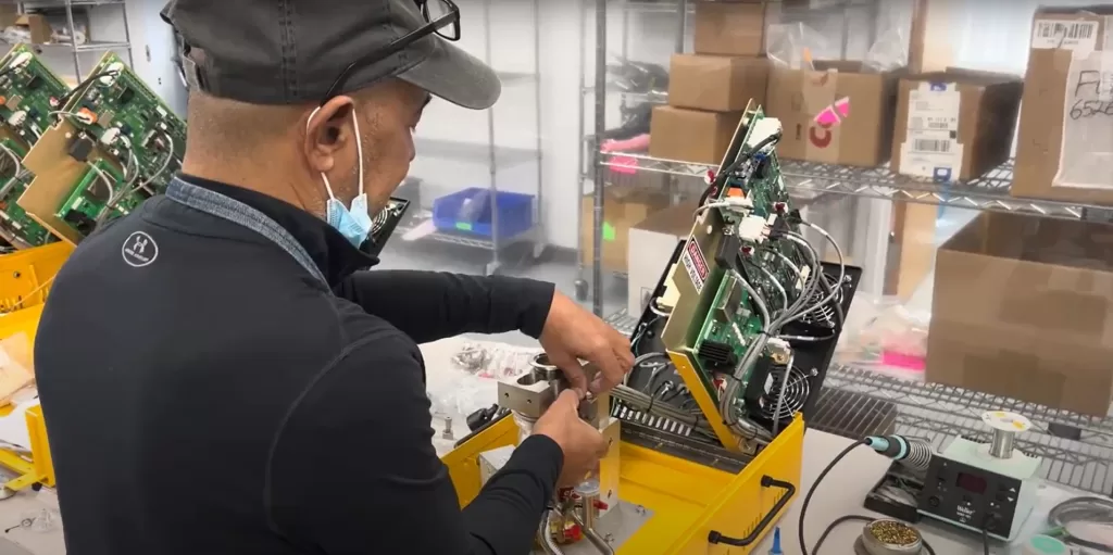 VIC technician assembling a helium leak tester in the facility